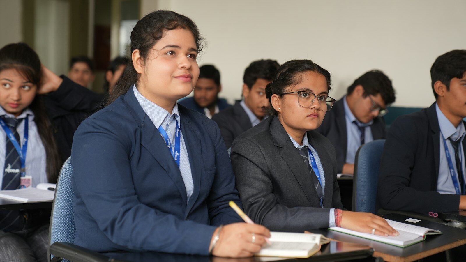 Attentive students in blazers taking notes in class