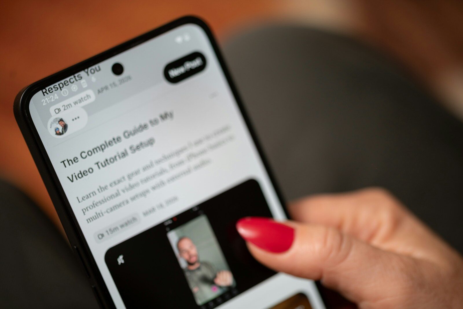 Person's hand scrolling through a video tutorial on a smartphone
